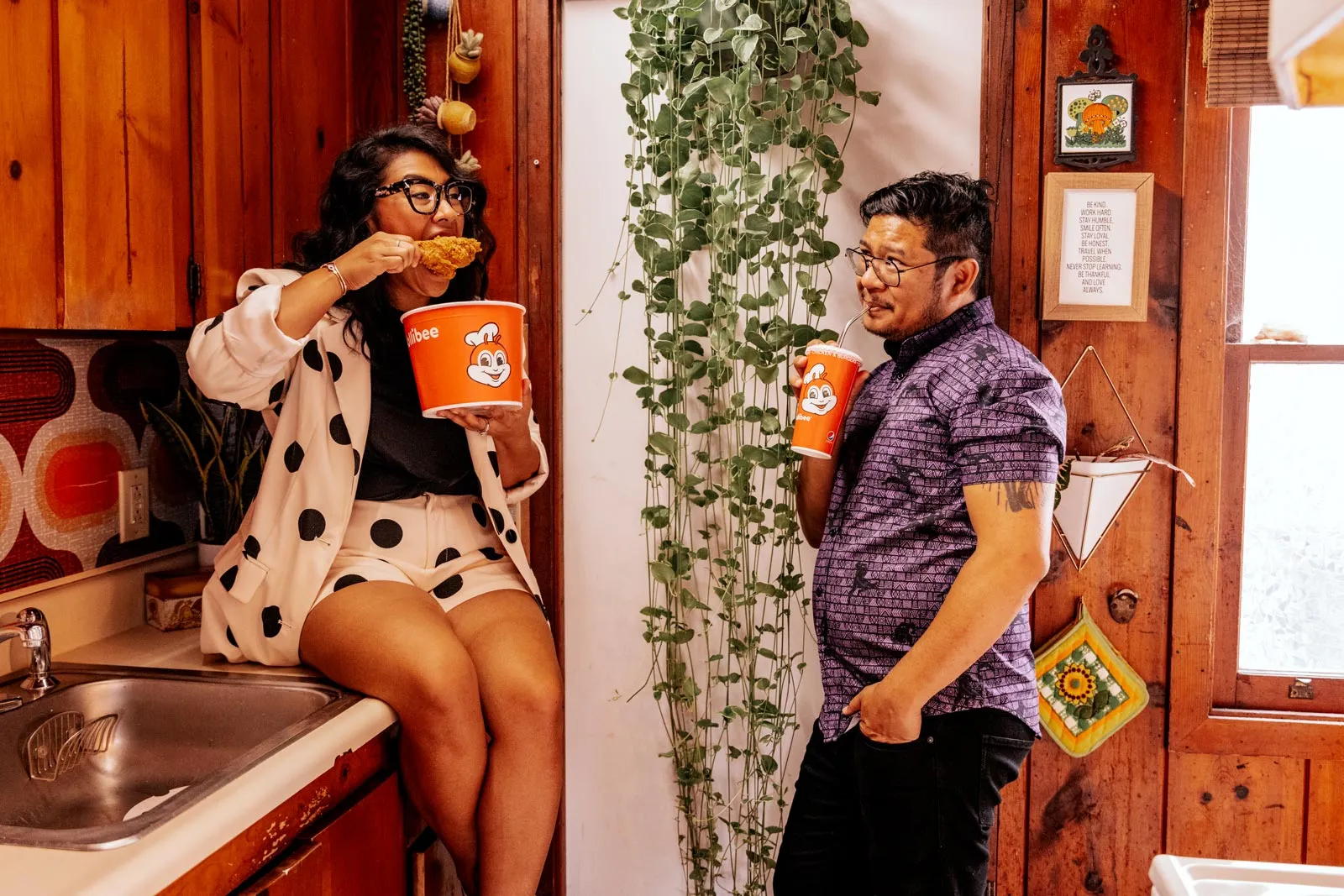 Jess and Nelson in their kitchen sharing a bucket of Jollibee fried chicken